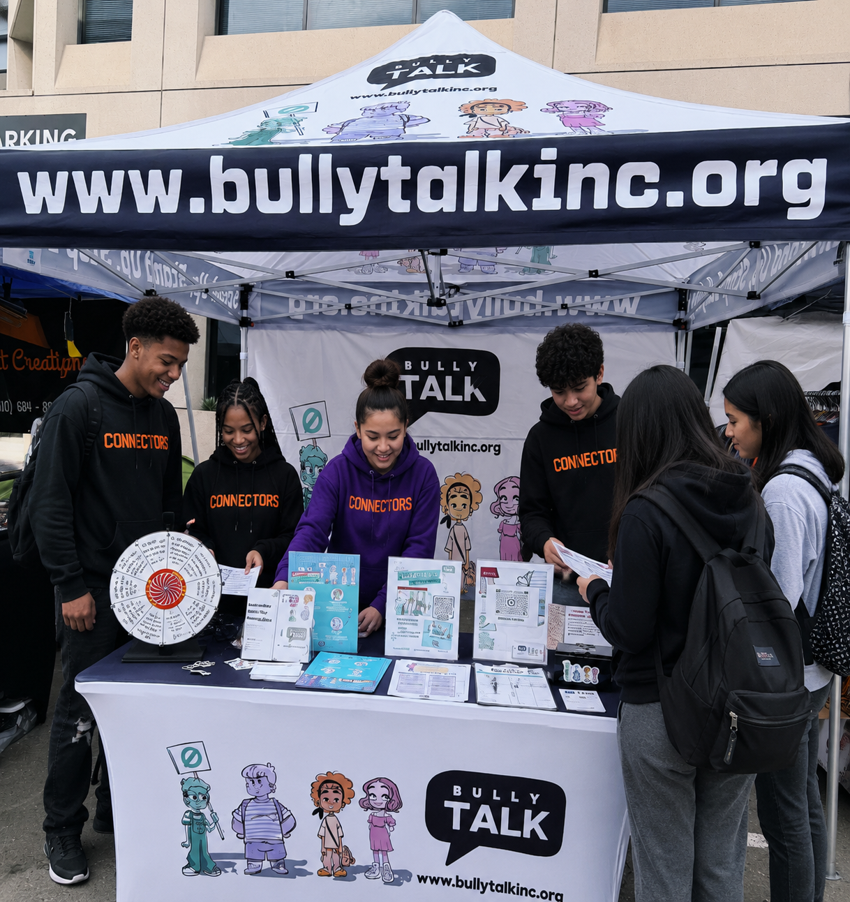 Bully Talk volunteers staffing a branded SPEAK UP. REACH OUT. BE KIND. community tabling booth